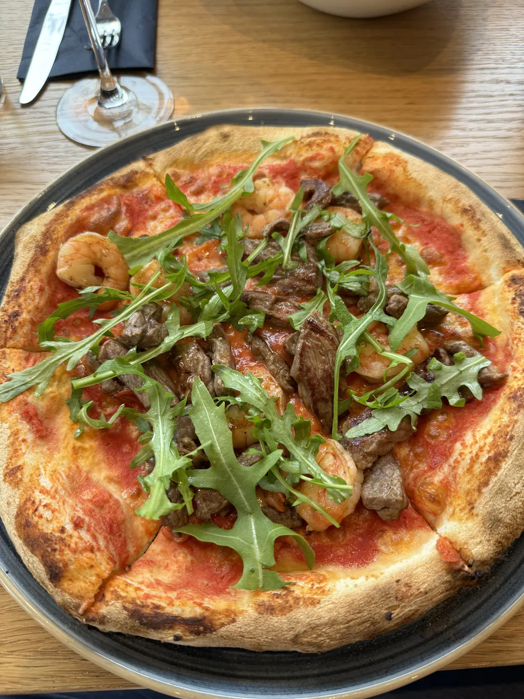 Pizza mit Rinderstreifen, Garnelen und Rucola