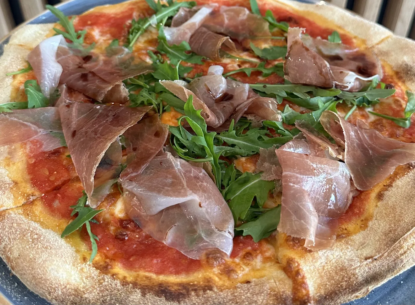 Pizza mit Parmaschinken und Rucola